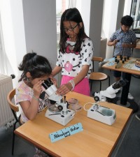 Huong zeigt, wie man mit dem Mikroskop umgeht.